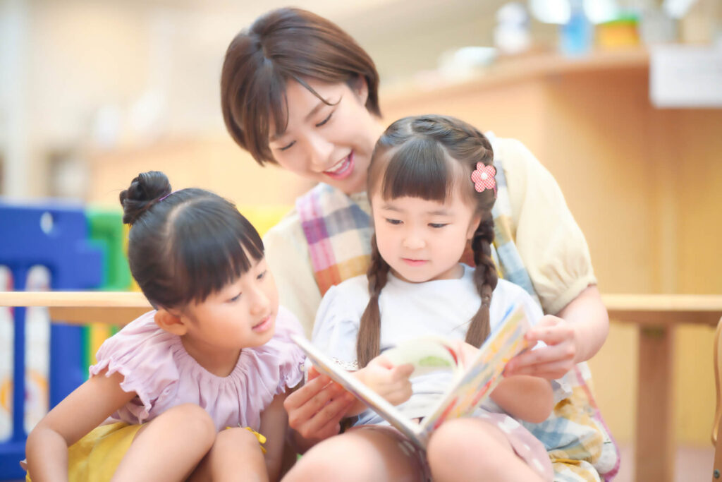 保育士さんが子供に読み聞かせをしている様子
